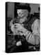 Elderly Man Knitting Garments During Drive to Provide Goods to Servicemen During the War-null-Premier Image Canvas