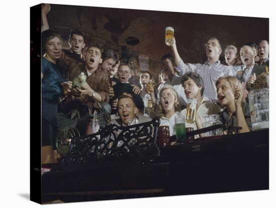 Elevated View of a Group of People as They Sing Along with a Pianist in a Unidentified Bar, 1959-Yale Joel-Premier Image Canvas