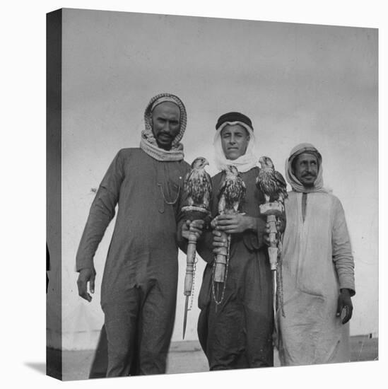 Falcon Trainers Holding onto Posts While their Birds Perch Atop Them-Bob Landry-Premier Image Canvas