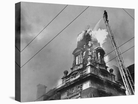 Fireman on Ladder Using a Hose to Extinguish Blazing Building Set Afire-Hans Wild-Premier Image Canvas