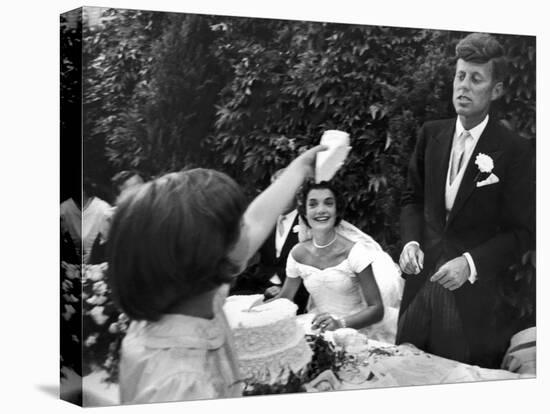 Flower Girl Janet Auchincloss Holding Up a Wedge of Wedding Cake for Bridegroom Sen. John Kennedy-Lisa Larsen-Premier Image Canvas