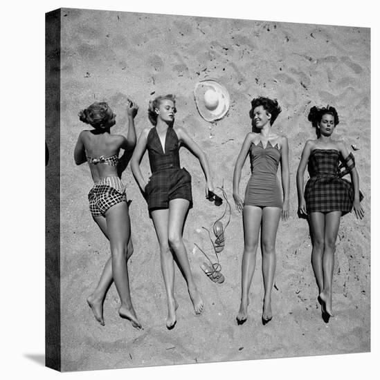 Four Models Showing Off the Latest Bathing Suit Fashions While Lying on a Sandy Florida Beach-Nina Leen-Premier Image Canvas