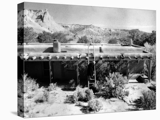 Georgia O'Keeffe Climbing a Ladder Outside Ghost Ranch, Her Desert Home-John Loengard-Premier Image Canvas