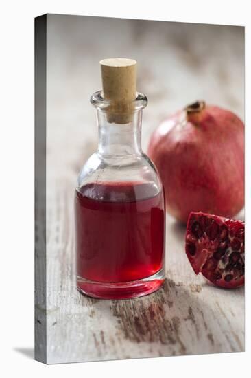 Glass Bottle with Pomegranate Juice and Pomegranate-Jana Ihle-Premier Image Canvas