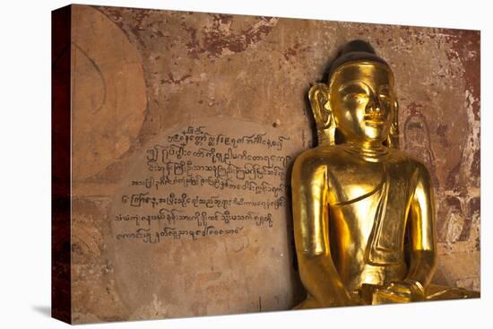 Golden Buddha Statue in Front of Burmese Writing on Wall, Bagan, Myanmar-Harry Marx-Premier Image Canvas