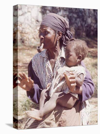 Haitian Woman Smoking a Pipe while Holding a Baby-Lynn Pelham-Premier Image Canvas