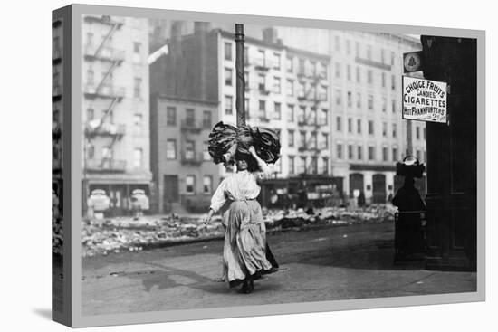 Immigrant Woman Walks Down Street Carrying a Pile of Clothing on Her Head-null-Stretched Canvas