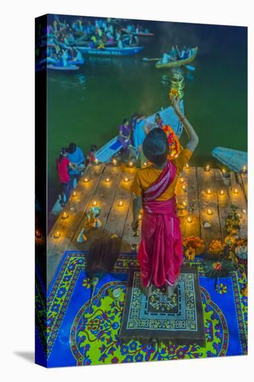 India, Varanasi Young Boy in Pink and Yellow Robes Holds Up an Offering to the Ganges River-Ellen Clark-Premier Image Canvas