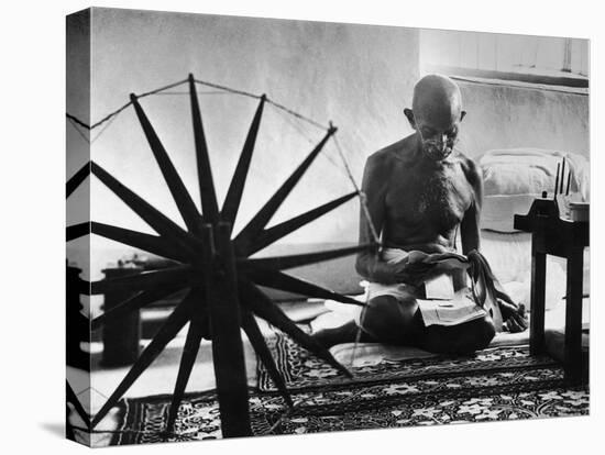 Indian Leader Mohandas Gandhi Reading as He Sits Cross Legged on Floor-Margaret Bourke-White-Premier Image Canvas