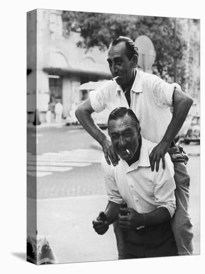 Italian Man Leaping Onto a Friend's Back in Casual Greeting While Crossing a Piazza-Paul Schutzer-Premier Image Canvas