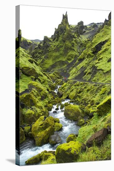 Jagged Moss Covered Peaks With A Mountain Stream Running Through With Hikers In The Distance-Erik Kruthoff-Stretched Canvas