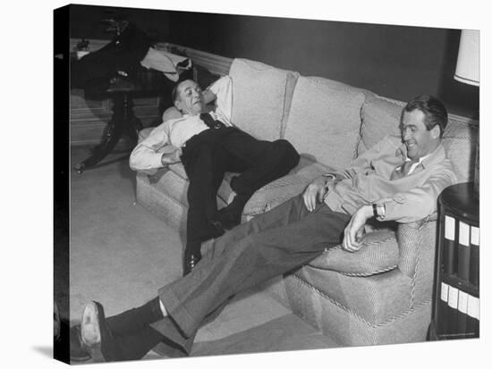 James Stewart Stretched Out on Office Sofa, Smiling, Producer Leland Hayward Slouches at Other End-John Florea-Premier Image Canvas