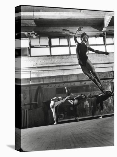 Jean Babilee, Star of Ballets Des Champs Elysees, Leaping During Practice as Other Dancers Watch-Gjon Mili-Premier Image Canvas