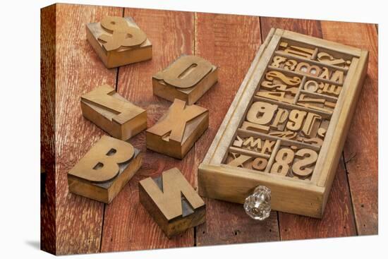Letterpress Wood Type Blocks in a Typesetter Drawer against Rustic Red Barn Wood-PixelsAway-Stretched Canvas