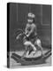 Little Boy on a Very Small Rocking Horse with a Whip in His Hand-null-Premier Image Canvas