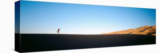 Low Angle View of a Woman Running in the Desert, Great Sand Dunes National Monument, Colorado, USA-null-Premier Image Canvas