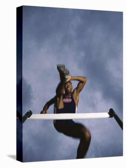 Low Angle View of a Young Man Jumping over a Hurdle-null-Premier Image Canvas