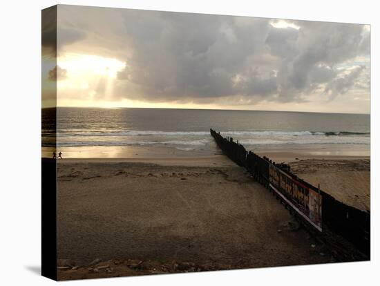 Man Jogs by the Beach Towards the Wall Dividing Mexico and the U.S. in Tijuana, Mexico-null-Premier Image Canvas