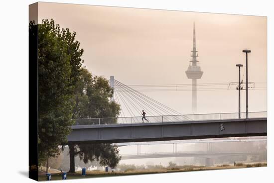 Mannheim, Baden-Württemberg, GER: Male Running Over Bridge Crossing River Neckar On Foggy Morning-Axel Brunst-Premier Image Canvas