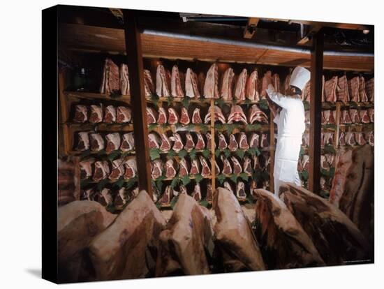 Meat Industry in the USA, Rib Roasts on Shelves and Butcher Making a Selection or Choice-Ralph Crane-Premier Image Canvas