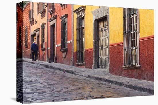 Mexico, San Miguel de Allende. Elderly man walks up sidewalk.-Don Paulson-Premier Image Canvas