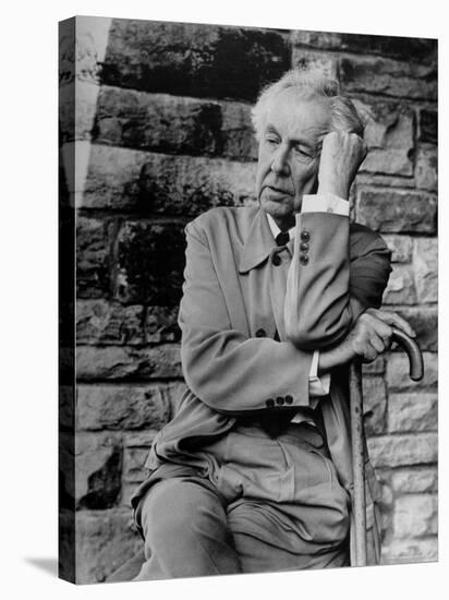 Midwestern Architect Frank Lloyd Wright sits against stone wall-Eliot Elisofon-Premier Image Canvas