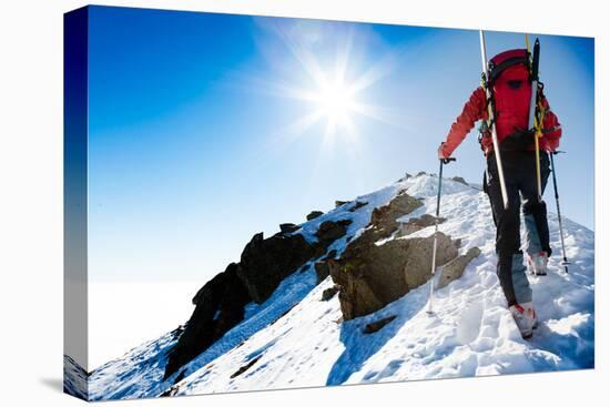 Mountaineer Walking up along a Snowy Ridge with the Skis in the Backpack. in Background a Shiny Bri-Roberto Caucino-Premier Image Canvas