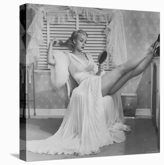 Movie Actress Carole Landis in Negligee as she Brushes Her Hair, Showing Off Gorgeous Legs-Peter Stackpole-Premier Image Canvas