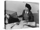 Mrs Teruko Kiyomura, bookkeeper, seated at desk, operating an adding machine while reading a ledger-Ansel Adams-Premier Image Canvas