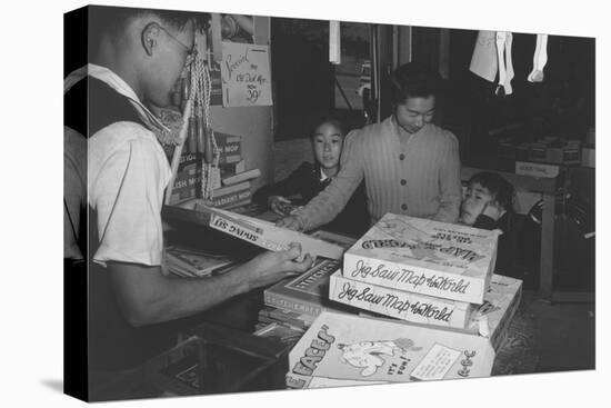 Mrs. Yaeko Nakamura shows her daughters jigsaw puzzles in a store at Manzanar, 1943-Ansel Adams-Premier Image Canvas