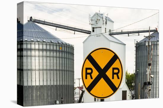 Nebraska, Blair, Washington County. Grain silo and equipment on Front Street, RR crossing sign.-Alison Jones-Premier Image Canvas