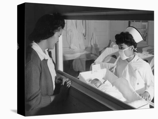 Nurse Aiko Hamaguchi shows new baby to mother in maternity ward, Manzanar War Relocation Center, CA-Ansel Adams-Premier Image Canvas