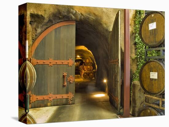 Oak Barrels Stacked Outside of Open Door To Aging Caves at Ironstone Winery, California, USA-Janis Miglavs-Premier Image Canvas