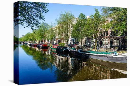 Old gabled buildings reflecting in a canal, Amsterdam, North Holland, The Netherlands-Fraser Hall-Premier Image Canvas