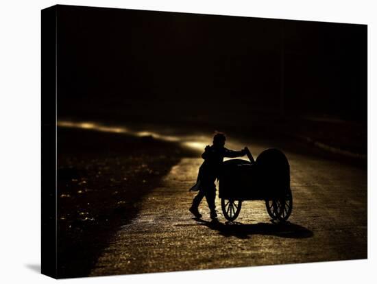 Pakistani Boy Pushes a Cart Along the Main Street in Rawalpindi, Pakistan-null-Premier Image Canvas