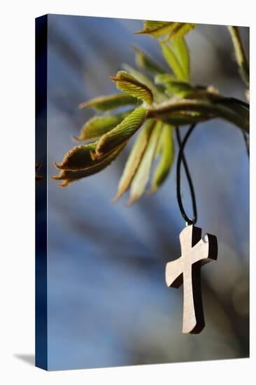 Pendant with cross on a young green chestnut leaf at springtime-null-Premier Image Canvas