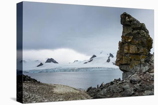 Penguins below dramatic rock formations, Half Moon Bay, South Sheltand Islands, Antarctica, Polar R-Michael Runkel-Premier Image Canvas