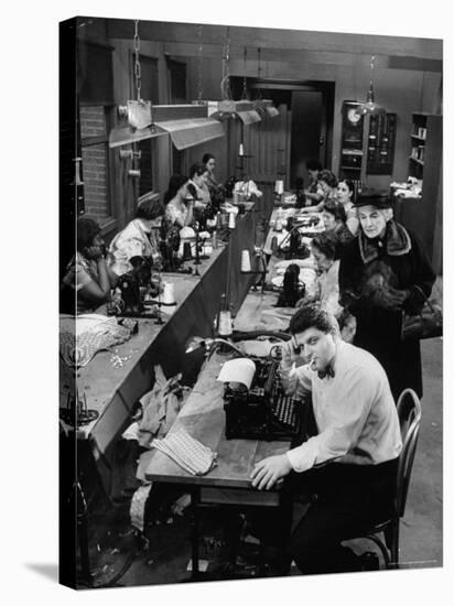 Playwright Paddy Chayefsky Sitting at Typewriter in Garment Factory With Workers on Sewing Machines-Michael Rougier-Premier Image Canvas