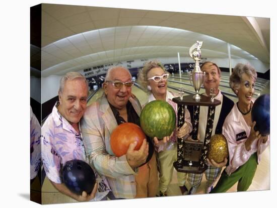 Portrait of a Group of Senior People Holding a Bowling Trophy at a Bowling Alley-null-Premier Image Canvas