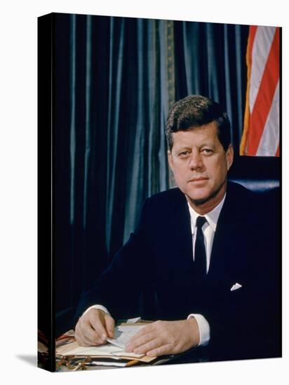 Pres. John F. Kennedy Sitting at His Desk, with Flag in Bkgrd-Alfred Eisenstaedt-Premier Image Canvas