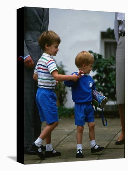 Prince Harry wearing a blue sweatshirt shorts and thomas the tank engine bag with Prince William on-null-Premier Image Canvas