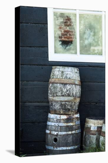 Rustic Barrels Lined Up Along an Old House Below a Window-Sheila Haddad-Premier Image Canvas