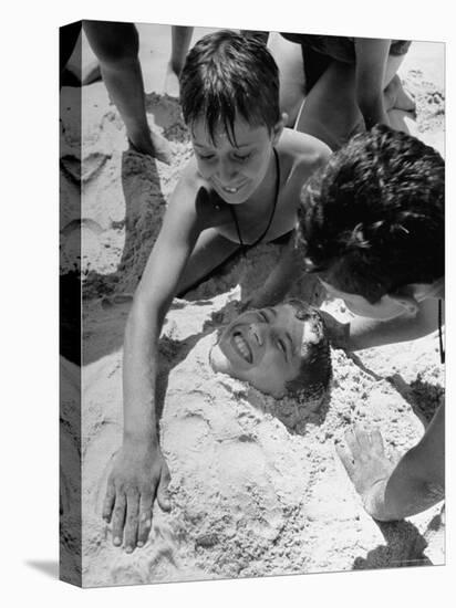 Settlement House Children Burying Boy under Sand at the Beach-Martha Holmes-Premier Image Canvas