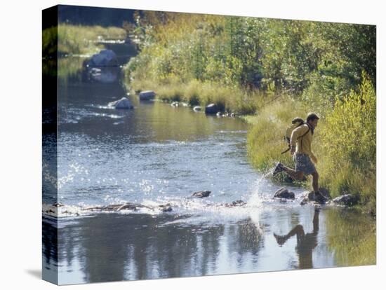 Side Profile of a View of a Young Man Running Across a River-null-Premier Image Canvas