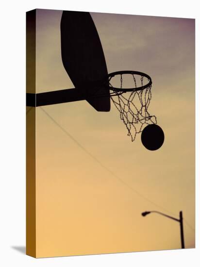 Silhouette of a Basketball Going Through a Basketball Net-null-Premier Image Canvas