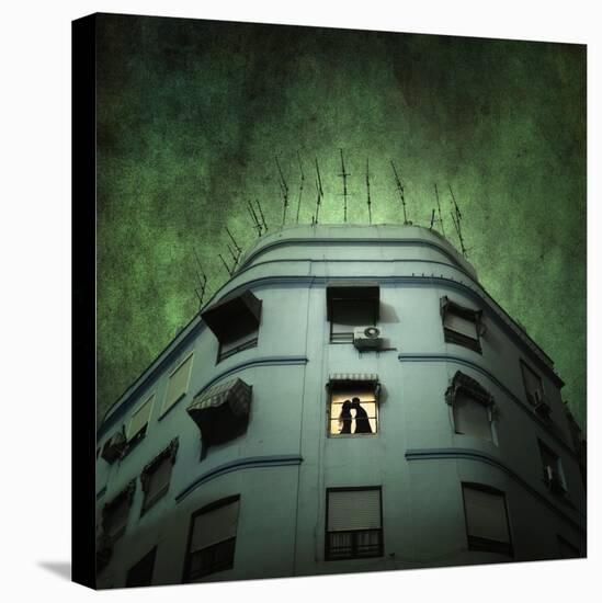 Silhouette of a Man and Woman Kissing in a Window of a Large Building with TV Ariels on the Roof-Luis Beltran-Premier Image Canvas