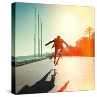 Silhouette of Skateboarder Jumping in City on Background of Promenade and Sea-Maxim Blinkov-Stretched Canvas
