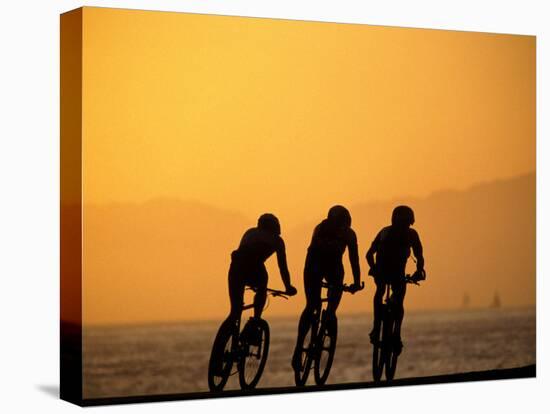 Silhouette of Three Men Riding on the Beach-Mitch Diamond-Premier Image Canvas