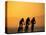 Silhouette of Three Men Riding on the Beach-Mitch Diamond-Premier Image Canvas