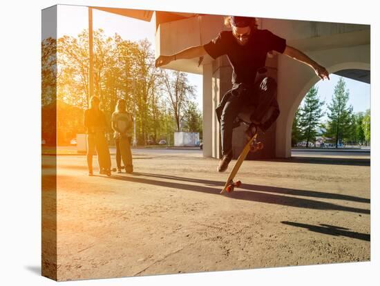 Silhouette Skateboarder Jumping in City on Skateboard under the Bridge. in the Background Two Young-Maxim Blinkov-Premier Image Canvas